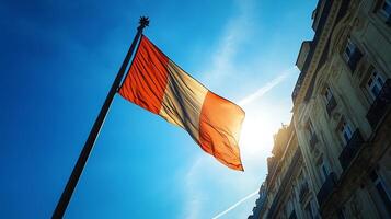 Dramatic Image of French Flag Waving Proudly Against Blue Sky and Historic Building Backdrop photo