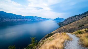 Serene Lake View with Mountain Backdrop and Cloudy Sky photo