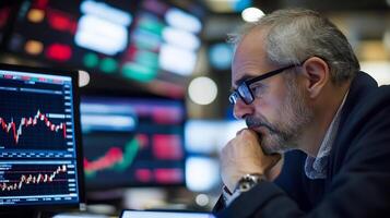 Focused Trader Analyzing Stock Market on Multiple Computer Screens photo