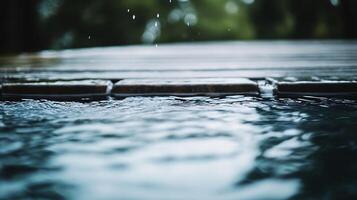 Calm water surface with raindrops creating ripples on wooden deck background photo