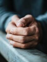 Close-up of hands in thoughtful pose on ledge expressing contemplation photo