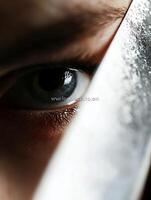 Intense and Mysterious Eye Watching from Behind Sharp Knife Edge photo
