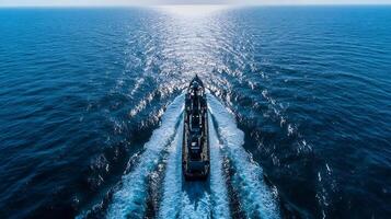 Aerial View of Ship Navigating Open Sea with Sunlight Reflecting on Water photo