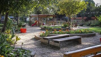 Charming natural playground with plants benches and play structures in a serene park setting photo