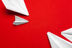 white paper airplane on a red background photo