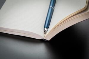 blank notebook and pen on the table photo