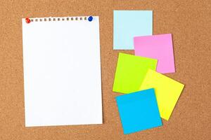 Cork board with several colorful blank notes with pins photo
