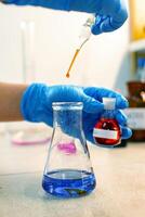 Chemistry experiment involves mixing colored liquids in laboratory setting with precise droplet measurements photo
