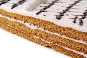 Layers of sweet dessert with creamy frosting and decorative chocolate drizzle on top photo