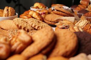 Baked goods displayed on a table featuring various cookies and pastries in a cozy setting photo