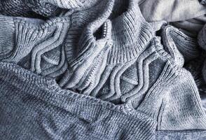 Warm knitted textile stack with the different texture in grey color palette close up photo