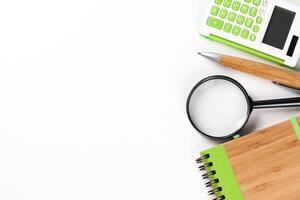 Calculator with a magnifying glass on a white background photo