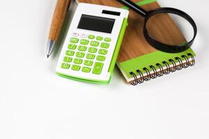 Calculator with a magnifying glass on a white background photo