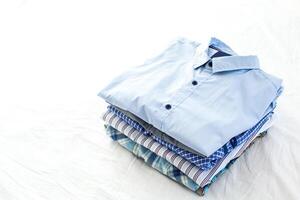 close up of ironed and folded shirts on table at home photo