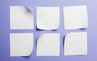 Blank paper tag label or sticker with copy space - flat lay on violet desktop background photo