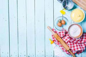 Preparation of the dough. Ingredients for the dough - Eggs and flour with a rolling pin. On wooden background. photo