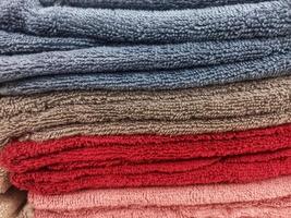 Stacks of clean, soft towels in a variety of colors photo