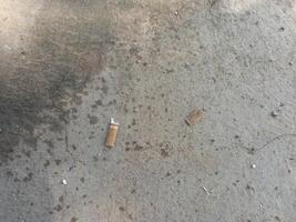 used cigarette butts on the concrete floor photo