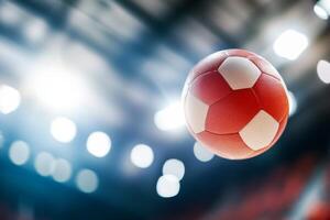 A high-speed soccer ball in mid-air during an indoor game under bright stadium lights photo