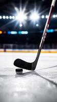 A close-up view of a hockey stick and puck on the ice during a game under bright arena lights photo