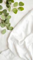 Fresh green eucalyptus leaves arranged on a soft white fabric background, creating a serene and calming atmosphere in a natural setting photo
