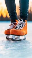 A skater glides across an outdoor ice rink at sunset, showcasing vibrant orange skates on a smooth surface photo