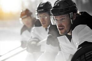 Three ice hockey players practicing on the rink during early morning light, showcasing concentration and teamwork in a competitive training session photo