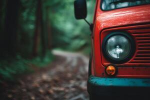 A vintage red vehicle parked on a forest road surrounded by lush greenery in the heart of nature during a quiet afternoon photo