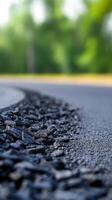 Close-up view of a winding road with gravel edging surrounded by lush greenery photo