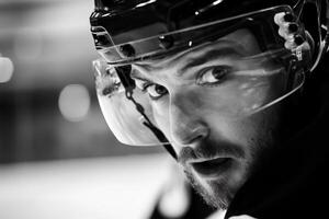 Intense hockey player focuses on the game while wearing a helmet during a match at a local ice rink in winter photo