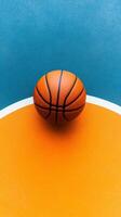A vibrant basketball rests on a colorful court surface , awaiting the next thrilling game photo