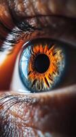 Close-up of a person's eye showcasing vibrant orange and blue iris patterns with fine details of eyelashes during daylight photo