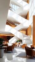Modern architectural design of a bright lobby featuring a unique staircase, cozy seating, and large windows illuminated by sunlight photo