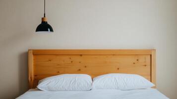 Simple and modern bedroom interior featuring a wooden bed frame with white bedding and a stylish pendant light photo