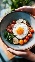 Delicious breakfast bowl featuring a sunny-side-up egg, fresh vegetables, prosciutto, and herbs in a natural setting with soft lighting photo