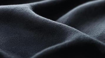 Close-up view of soft, dark fabric showcasing texture and folds in a well-lit indoor photo