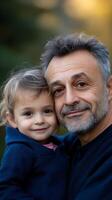 A grandfather embraces his smiling granddaughter in a serene outdoor setting during golden hour photo