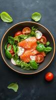 Fresh salmon salad featuring vibrant greens and cherry tomatoes served in a rustic bowl against a dark background photo