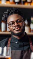 A smiling bartender in a black shirt serves customers at a bustling bar during the evening hours photo