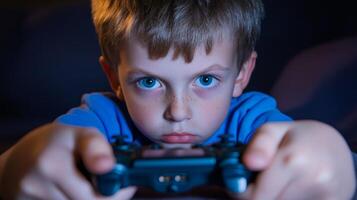 Young boy intensely playing games in a dimly lit room during an evening gaming session photo