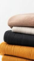 A cozy stack of knitted sweaters in warm colors photo