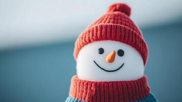 A cheerful snowman wears a red hat and scarf against a soft blue background on a bright winter day photo