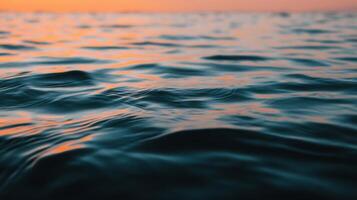 Calm ocean waves reflecting the warm colors of sunset on a tranquil evening at sea photo
