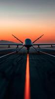 Drone on the runway at sunset with vibrant colors illuminating the sky near the mountains photo