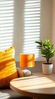 A cozy corner with bright sunlight casting shadows on a table and a vibrant orange lamp beside a green plant in a modern setting photo