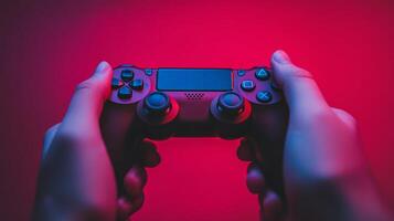A person holding a modern gaming controller in a colorful room with vibrant red and blue lighting at night photo