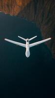 Drone flying over the ocean near a rugged coastline during golden hour capturing stunning aerial views of nature and the landscape photo