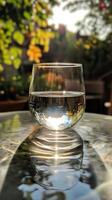 Serene Water Glass in Garden Sunlight photo