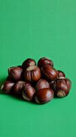 A Bountiful Heap of Hazelnuts on a Vibrant Green Background photo