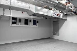 Industrial basement room with ventilation system and empty floor space in an urban setting photo